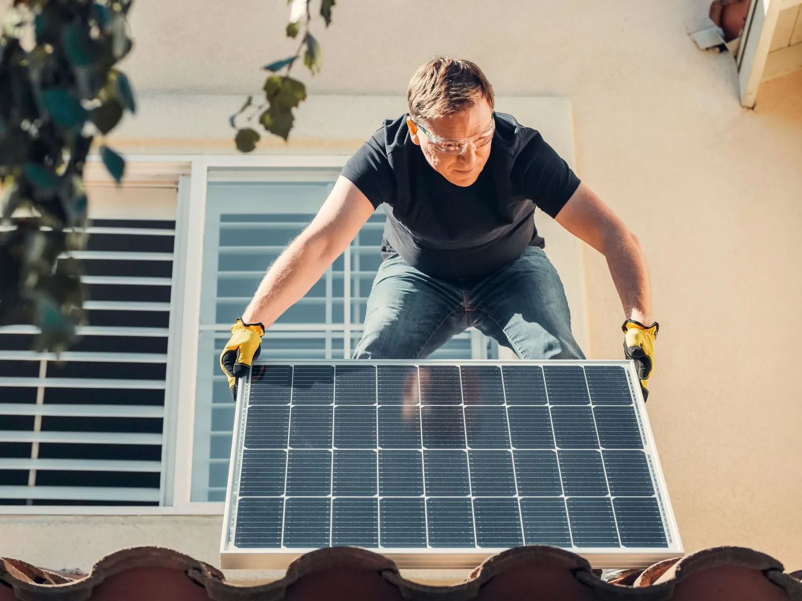 Installer securing a solar panel to a roof rail